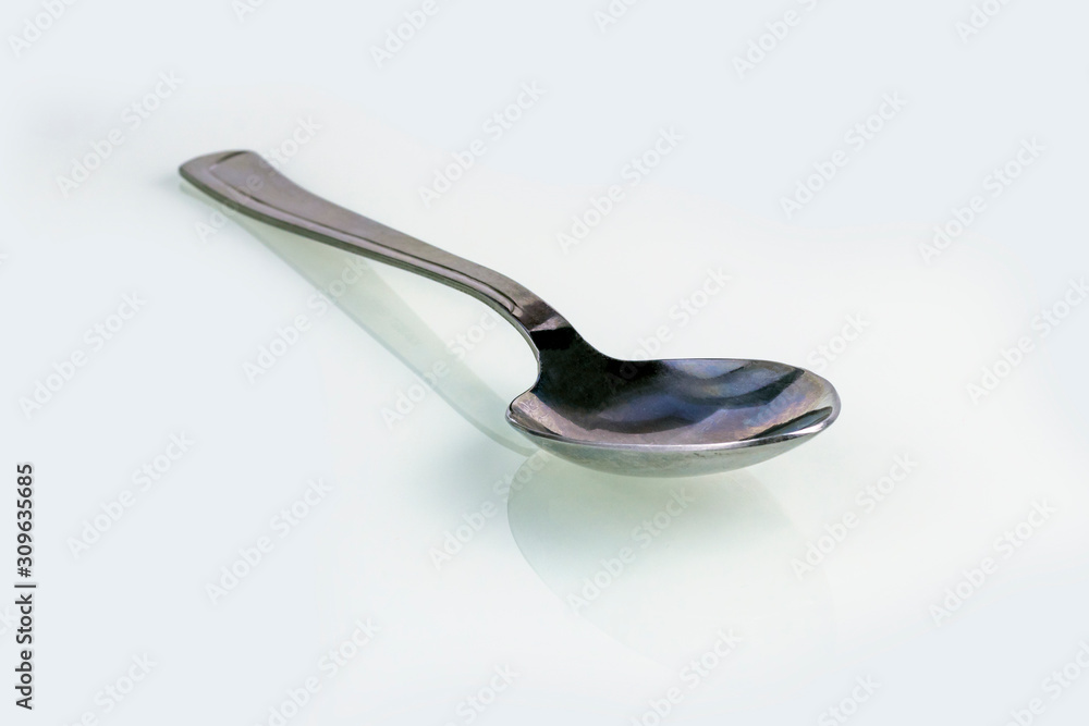 close-up. empty steel spoon on a white background. insulation. close-up. empty steel spoon on a white background. insulation.