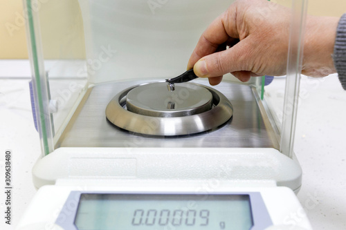Photography The student weighs a small metal object on an accurate analytical balance