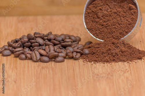 Coffee beans and ground powder on a wooden background. Top view with copy space