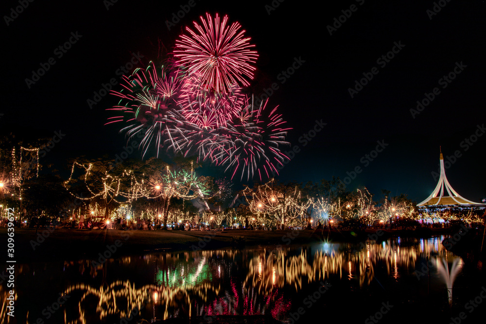 Fototapeta premium Multicolored bright festive fireworks in the dark sky background.Beautiful colorful fireworks for celebration holiday concept.