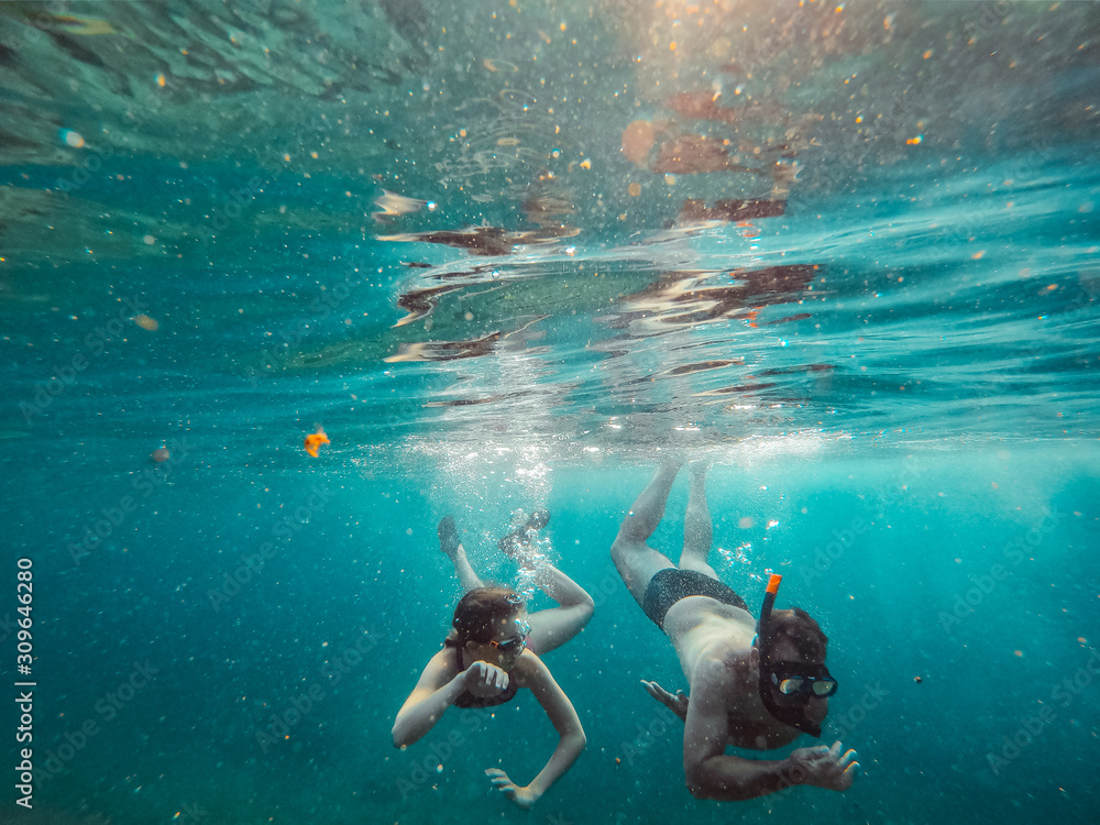 Father and daughter snorkeling in a tropical water