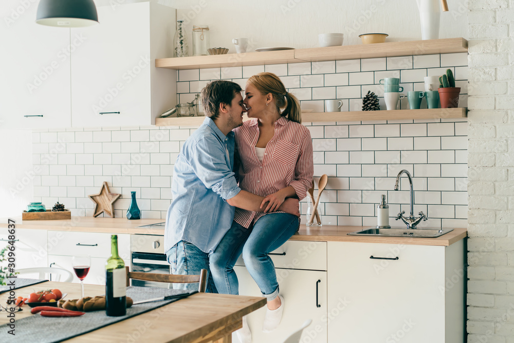 Happy couple embracing in kitchen Happy couple embracing in kitchen
