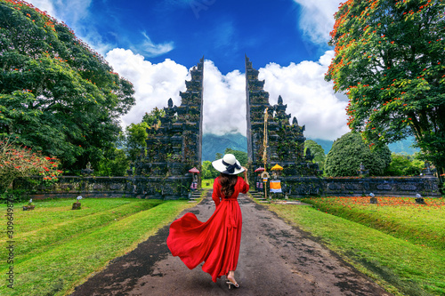 Woman walking at big entrance gate, Bali in Indonesia. photo