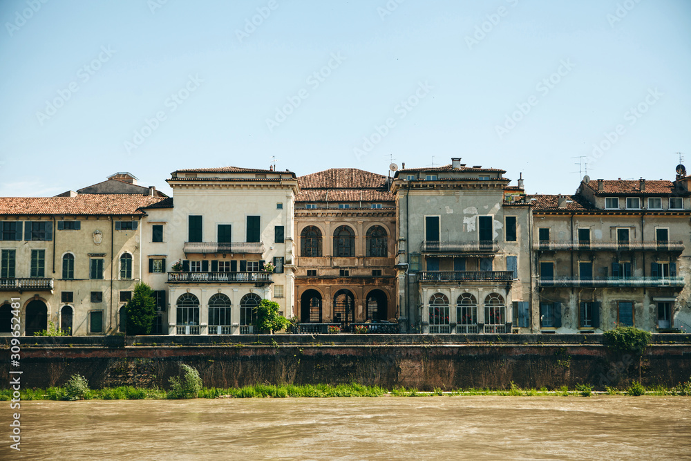 View of traditional residential buildings along the river promenade in Verona in Italy