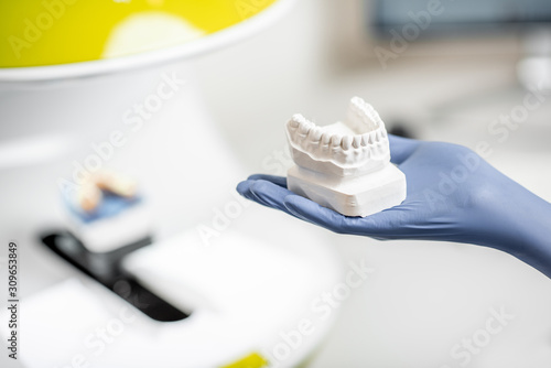 Holding a gypsum model of artificial jaw on the 3d scanner at the dental laboratory