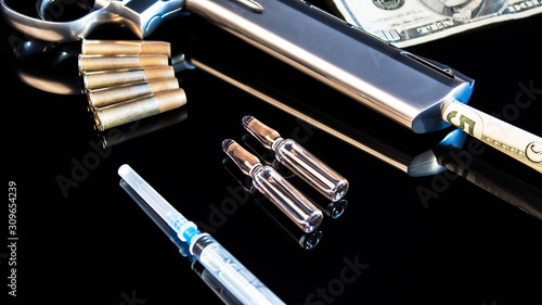 Wallpaper Mural Five dollars in a pistol on a black table with a syringe and cartridges.Sale, possession and distribution of drugs. Problems of youth with drug addiction,law and crime.Drug trafficking, drug cartels. Torontodigital.ca
