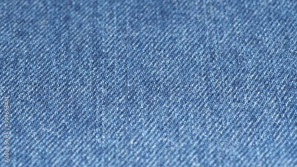 Jeans fabric plain surface, low angle. Shallow DOF, focus at center. Denim textile tracking. 4K 422 10 bit