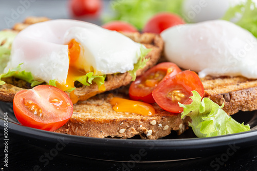 Breakfast toasts and poached eggs, served with lettuce and tomatoes.