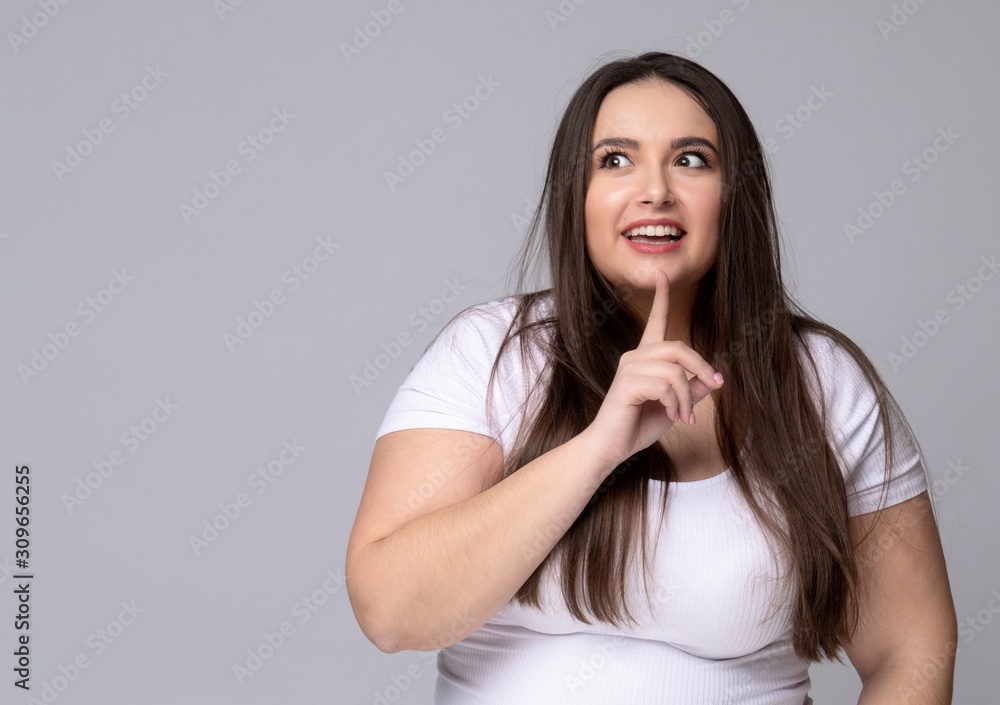 Girl holds finger at mouth urging to keep silence Girl holds finger at mouth urging to keep silence