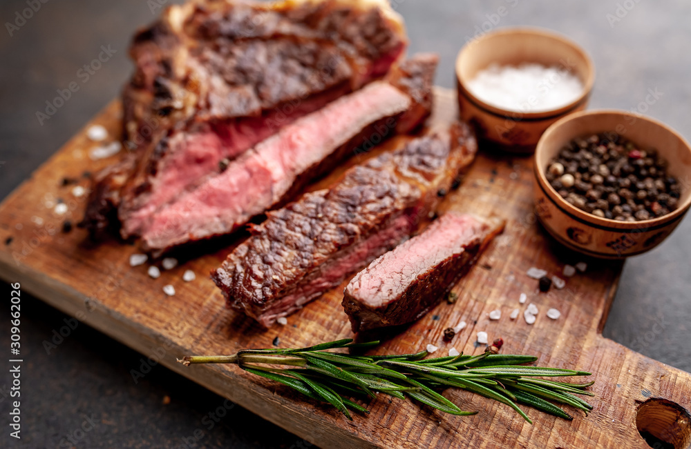 Grilled beef steak with spices. on stone background