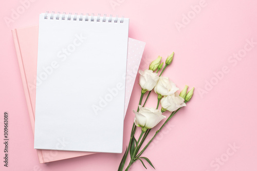 Beautiful white eustoma flower and notebook on pink background © KatrinaEra