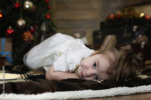 Сhild is sitting with Christmas decorations