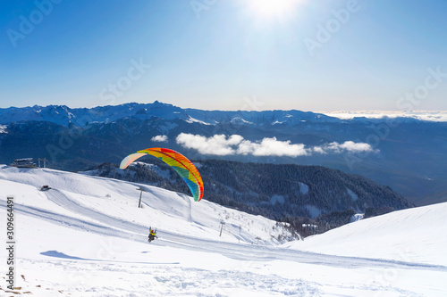 Paragliding on the background of snow-covered white mountains