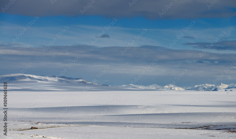 Lone truck on the Dalton Highway driving through the snow covered Brooks Range mountains Alaska
