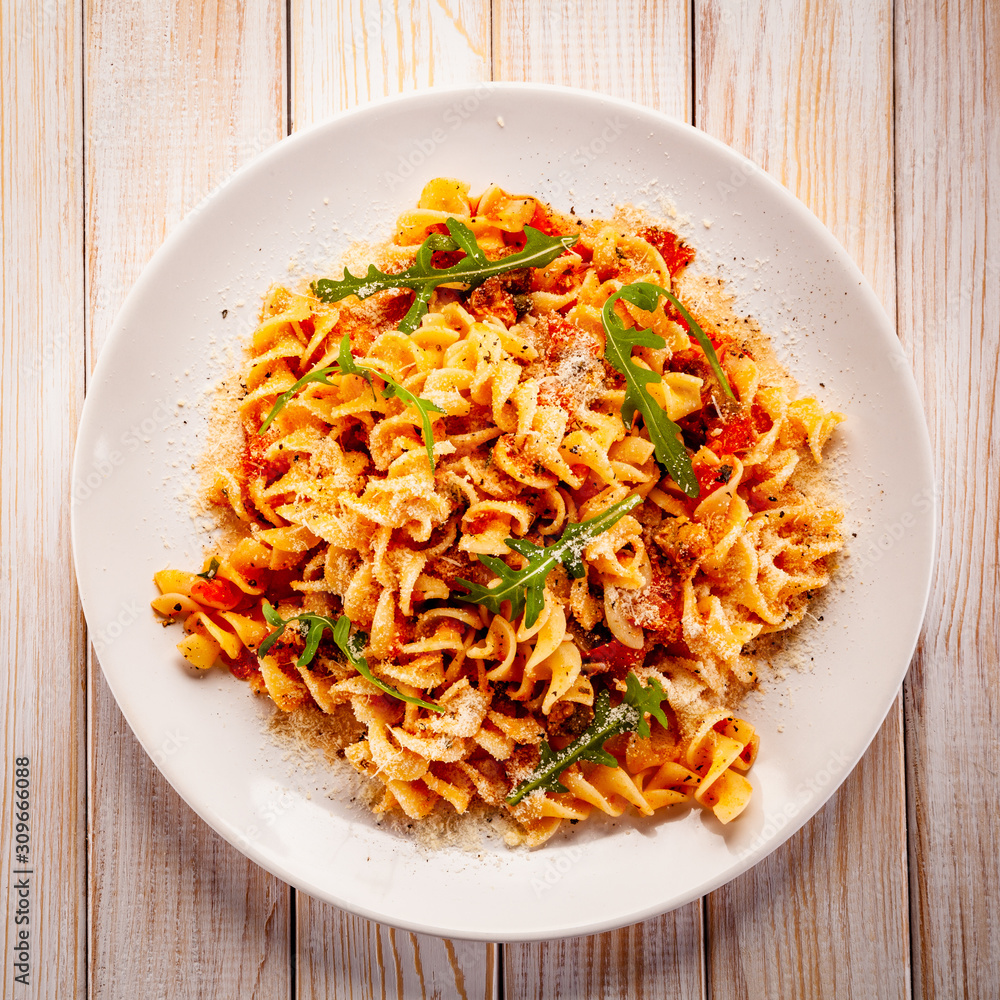 Fusilli with sausages and vegetables on wooden table Fusilli with sausages and vegetables on wooden table