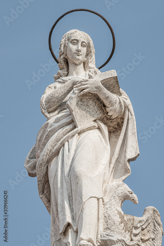 Ancient aged sculpture of beautiful Holy Maria at roof of Santa Maria Assunta Jesuits Church in Venice, Italy, details, closeup