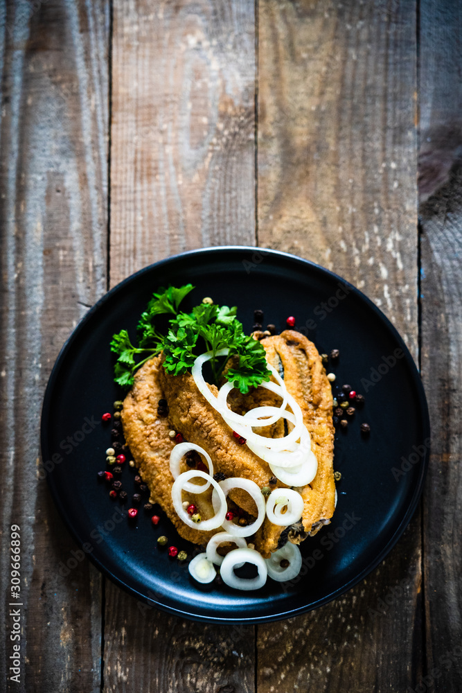 Fish dish - marinated fried fish fillet on wooden table
