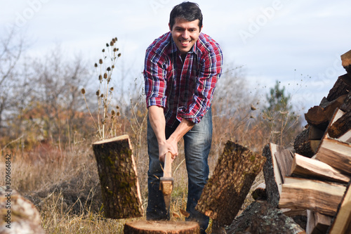 Lumberjack chopping wood for winter  Young man chopping woods with an axe