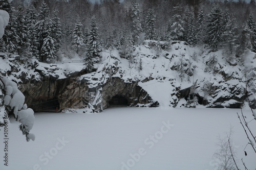 Christmas trees on a steep cliff near the frozen river