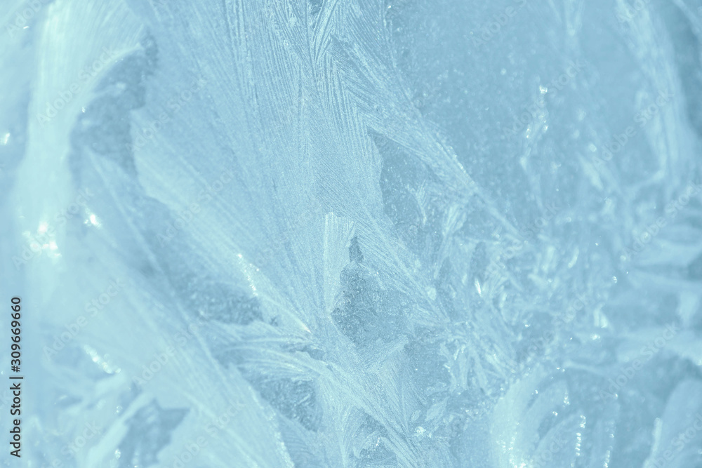 Obraz premium Frosty patterns on the window in winter. Natural abstract background of blue color