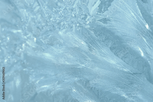 Frosty patterns on the window in winter. Natural abstract background of blue color