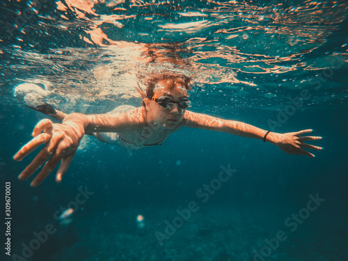 Underwater photo of girl swimming in the sea