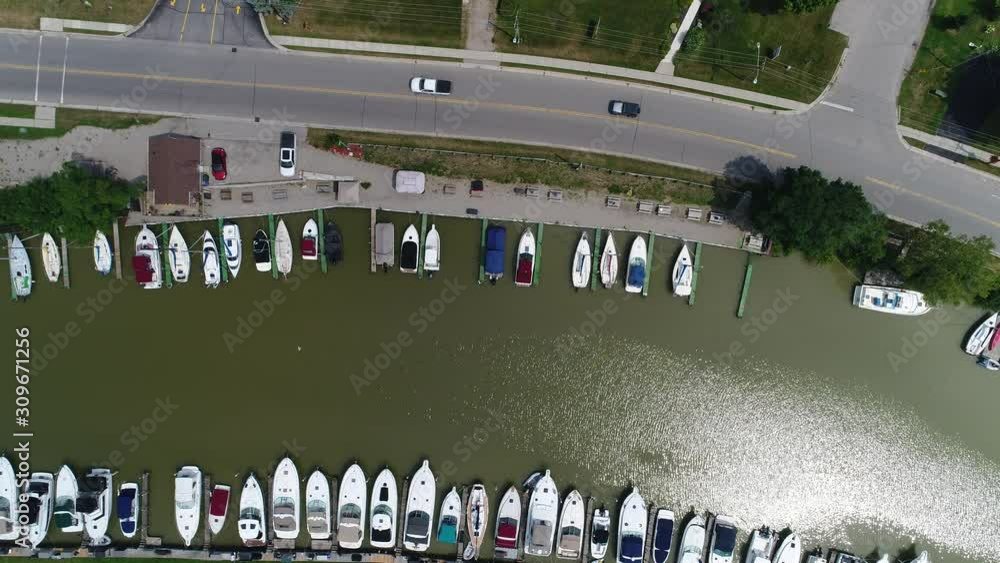 Hovering Over Water With Boats Docked And Cars Vehicles Traffic Driving On Road By Powerlines Hovering Over Water With Boats Docked And Cars Vehicles Traffic Driving On Road By Powerlines