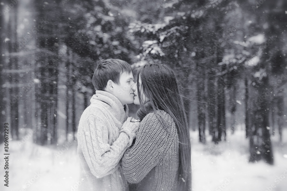 Fototapeta premium A loving couple on a winter walk. Man and woman on a date in the park in winter. Friends in a winter park