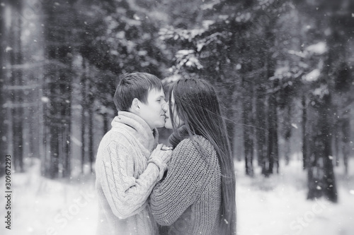 A loving couple on a winter walk. Man and woman on a date in the park in winter. Friends in a winter park