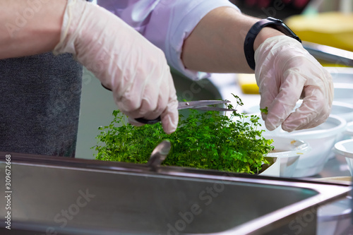 Hands of chef with a pair o...