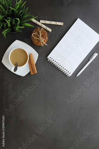 Office desktop background with a cup of coffee and writing utensils. Manager's desk, pen, notebook, computer.