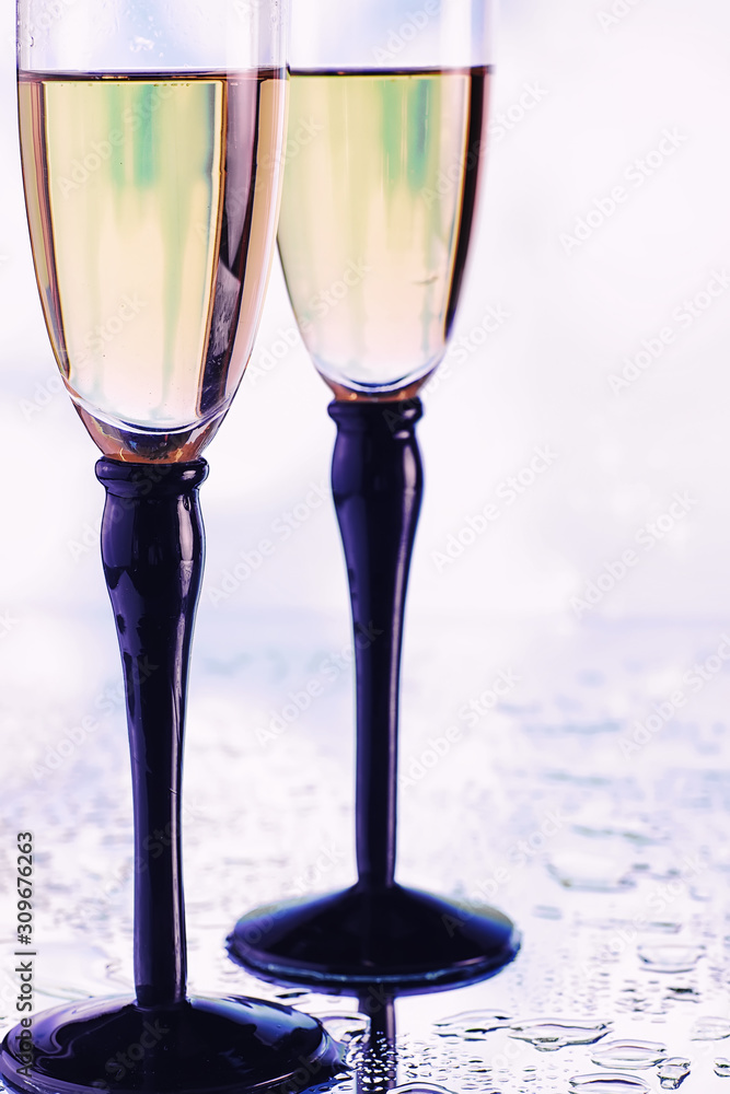 Obraz premium Background with tall glasses for sparkling wines. Champagne and spray in glass glasses. Celebratory drink with reflection.