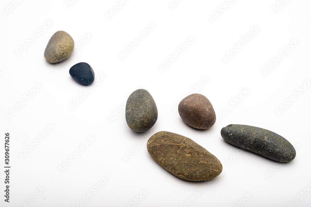 Scattered sea pebbles. Smooth gray and black stones isolated on white background. Top view Scattered sea pebbles. Smooth gray and black stones isolated on white background. Top view