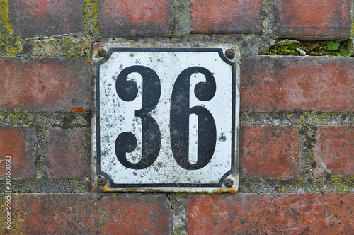 A house number plaque, showing the number thirty six (36)