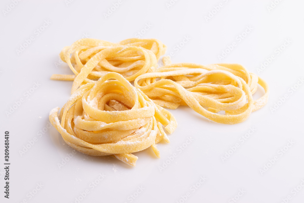 Home made pasta on white background, soft light, copy space Home made pasta on white background, soft light, copy space