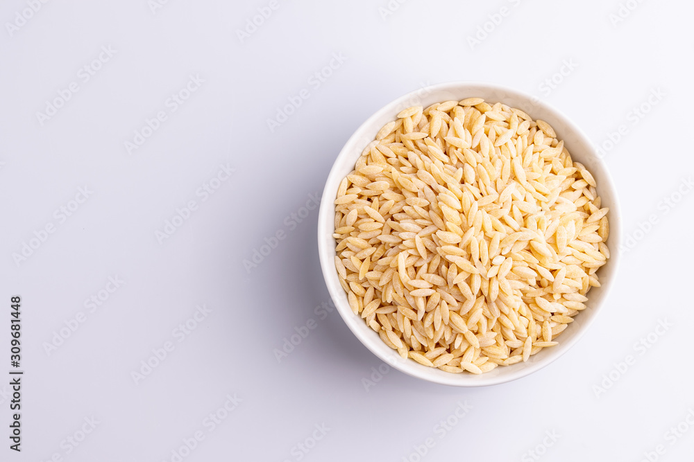 Orzo pasta, isolated on white background. Italian orzo pasta shaped like grains of rice, copy space, soft light Orzo pasta, isolated on white background. Italian orzo pasta shaped like grains of rice, copy space, soft light