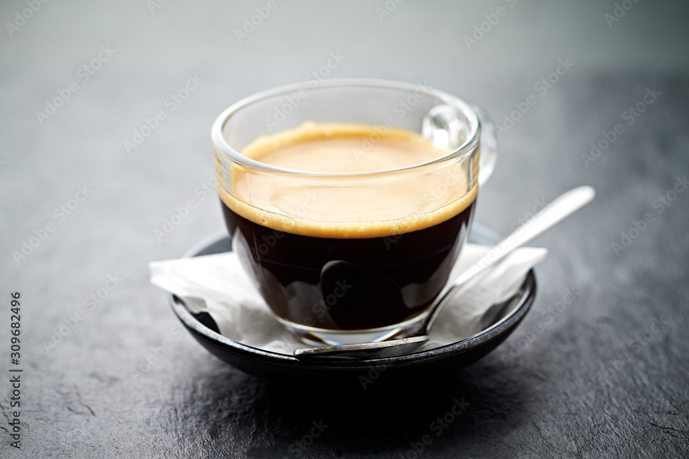Coffee in glass cup on stone background. Close up. Coffee in glass cup on stone background. Close up.