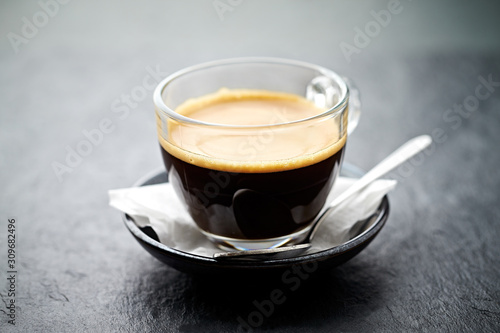 Coffee in glass cup on stone background. Close up. 