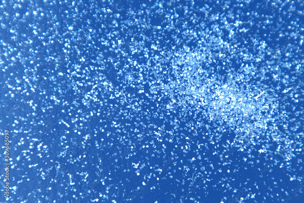 Obraz premium Abstract background glitter snow on classic blue surface.