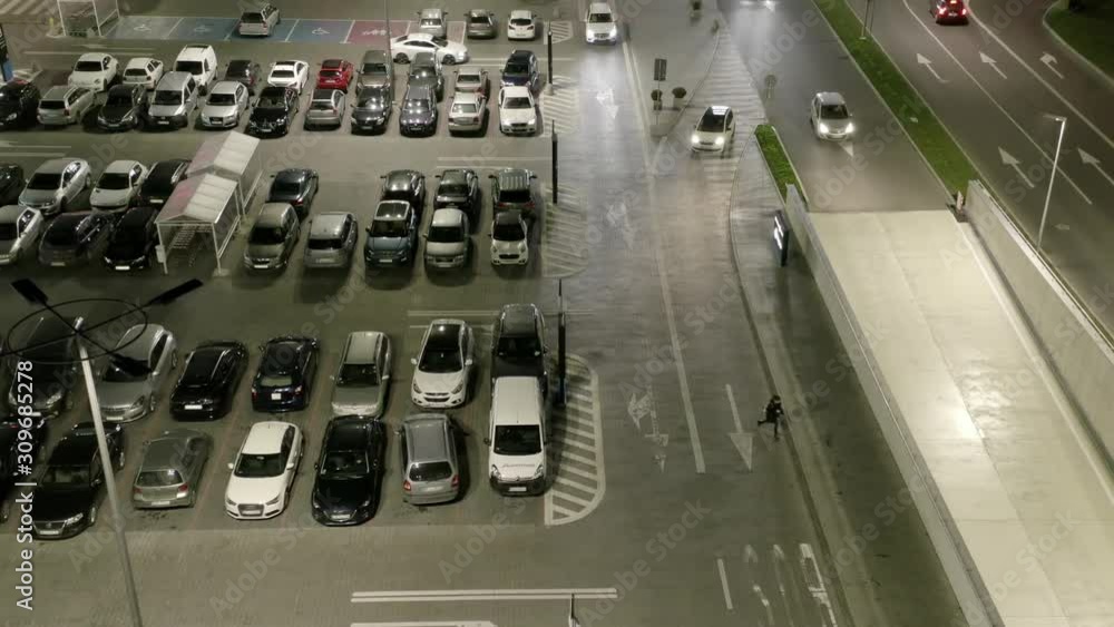 Warsaw, Poland. 13. December. 2019. Drone flies over cars in a parking lot under night lighting. Aerial view of night parking near a shopping center in a suburb of Warsaw. Warsaw, Poland. 13. December. 2019. Drone flies over cars in a parking lot under night lighting. Aerial view of night parking near a shopping center in a suburb of Warsaw.