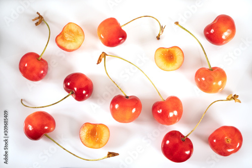 Scattering of fresh sweet ripe cherries on the table isolated on a white background. Suitable for prints, design, production, labels, for use in invitations, greeting cards. Top view
