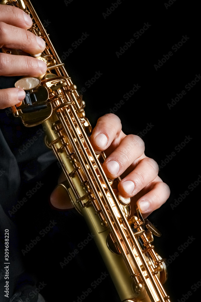 Obraz premium soprano saxophone in hands on a black background