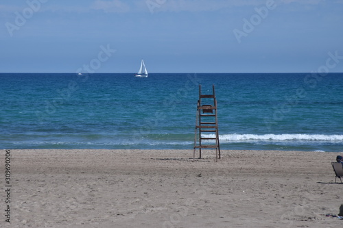 Fototapeta Naklejka Na Ścianę i Meble -  Barco de vela en el mar y silla salvavidas