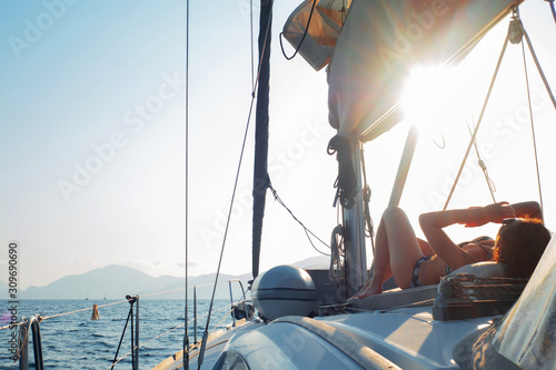 Boat trip on a yacht, A young woman sunbathing on the deck of a sailing boat.