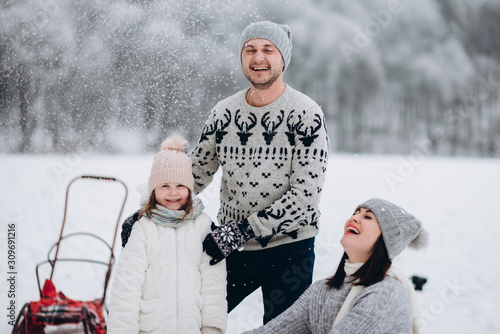 Daddy sledges his daughter for a walk. Family winter vacation