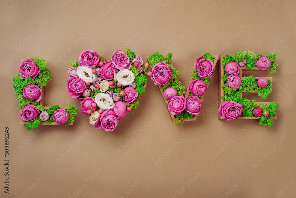 Volume letters LOVE word with stabilized moss and roses on craft paper