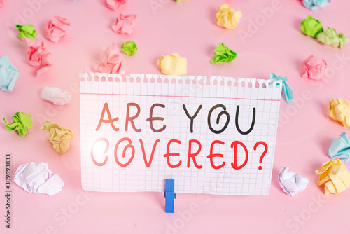 Writing note showing Are You Covered Question. Business concept for asking showing if they had insurance in work or life Colored crumpled papers empty reminder pink floor background clothespin