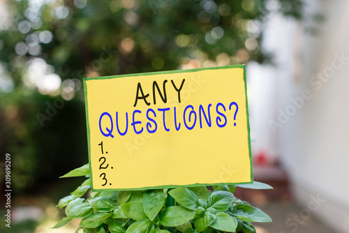 Writing note showing Any Questions Question. Business concept for you say write order to ask demonstrating about something Plain paper attached to stick and placed in the grassy land © Artur