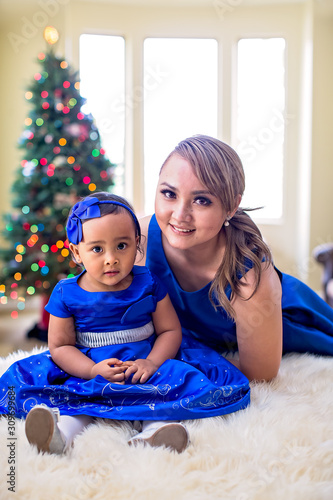 Mother and young daughter pose for a Christmas photo