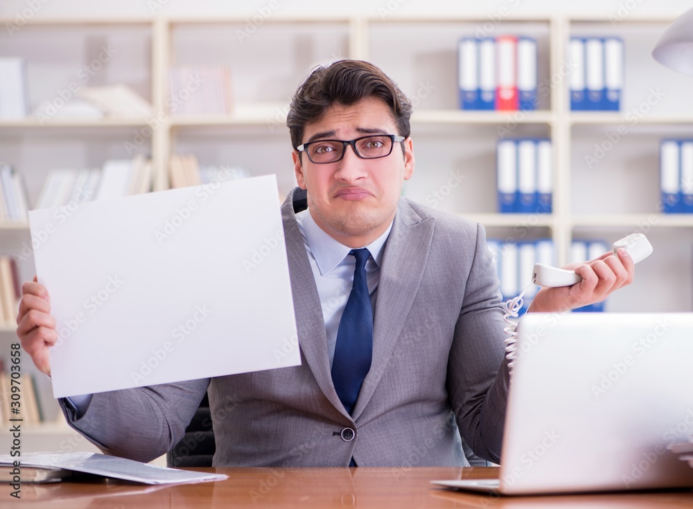 Fototapeta premium Businessman in office holding a blank message board